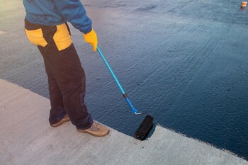 Roofer applying roof coating in Southwest Ranches, FL